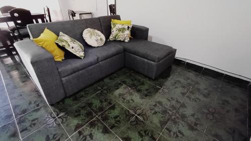 a gray couch with pillows on it in a living room at El Corazón de Quepos in Quepos