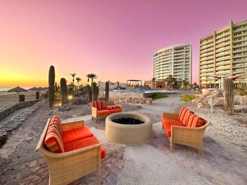 a patio with chairs and a fire pit on the beach at Serenity by the Sea Stunning Beachfront Condo #1003 in Playa Encanto