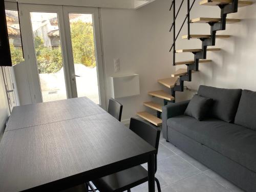 un salon avec une table et un escalier dans l'établissement Studio pour 2 personnes - Cossi, à Saintes-Maries-de-la-Mer