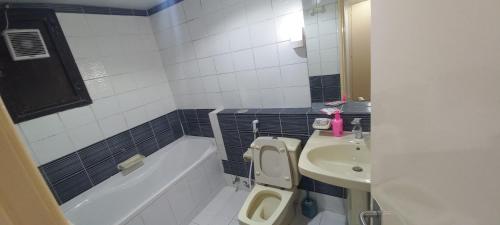 a bathroom with a tub and a toilet and a sink at DOS #FaMiLy RooM AwAy Fr0m HoMe in Abu Dhabi