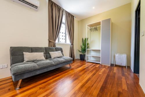 a living room with a couch on a wooden floor at La Ferringhi Villa - Tropical Collection, by ALV in Batu Ferringhi