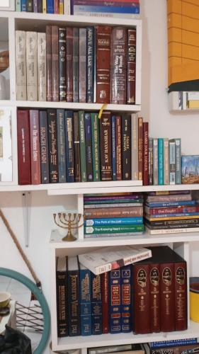 a book shelf filled with lots of books at Garden Apartment Bnai Brak in Bene Beraq