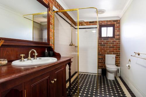 a bathroom with a sink and a toilet and a mirror at Eagles Point I Water Views I Pet Friendly in Callala Bay