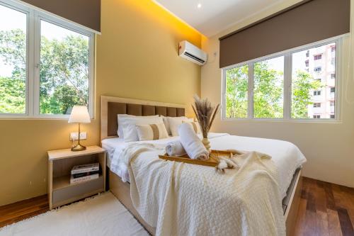 a bedroom with a bed and two windows at La Ferringhi Villa - Tropical Collection, by ALV in Batu Ferringhi