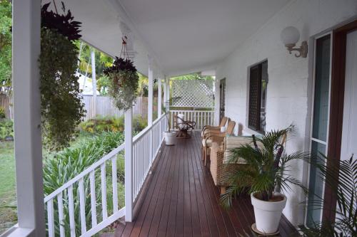 a porch with potted plants on a house at South Pacific Bed & Breakfast in Clifton Beach