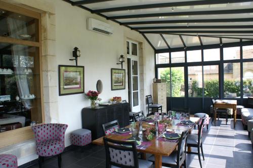 a dining room with tables and chairs and windows at B&B Vassy Etaule in Avallon