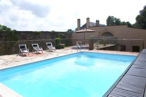 einen Pool mit zwei Stühlen und ein Haus in der Unterkunft B&B Vassy Etaule in Avallon