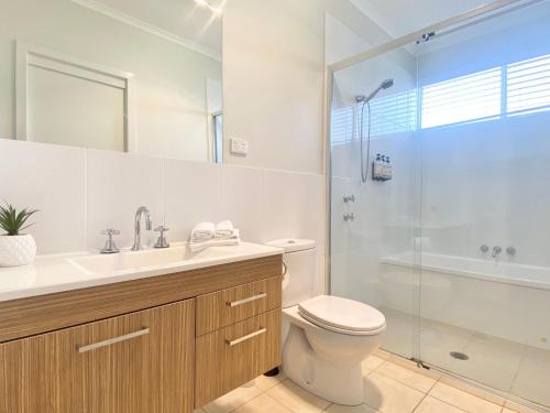 ケイブス・ビーチにあるAqua Villa at Caves Beach Villasのトイレ、洗面台、シャワー付きのバスルーム