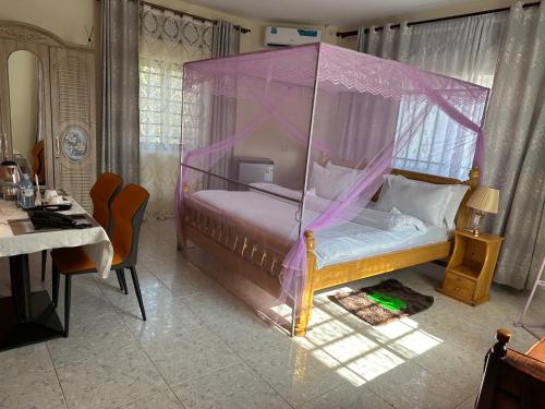 a bedroom with a bed with a canopy at Lakeshore Bed and Breakfast in Entebbe
