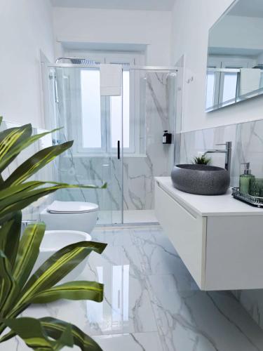 a white bathroom with a toilet and a sink at Morgagni Suites in Bologna