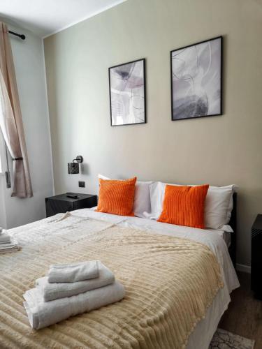 a bedroom with a large bed with orange pillows at Morgagni Suites in Bologna