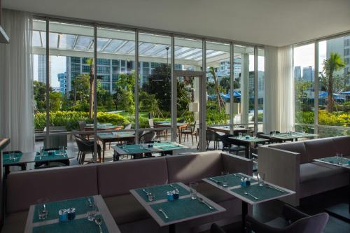 雅加達的住宿－雅加達塞蒂亞布迪輝盛坊國際公寓，餐厅设有桌椅和大窗户。