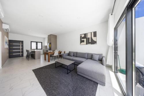 a living room with a couch and a table at Charming 2 BR Oasis in Oranjestad by Bocobay in Pos Abao