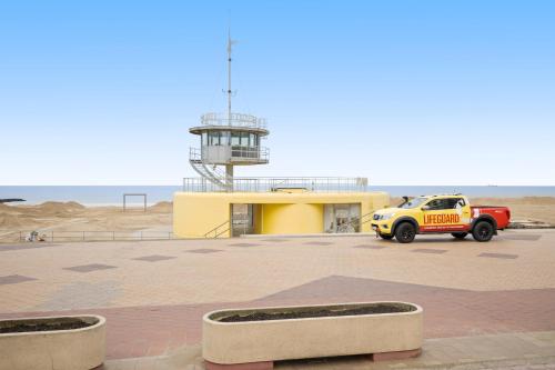 a yellow truck parked in a parking lot near the beach at Ambrose 23 Parking in Knokke