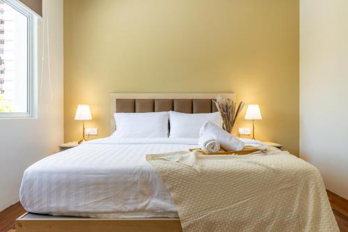 a bedroom with a large white bed with two lamps at La Ferringhi Villa - Tropical Collection, by ALV in Batu Ferringhi