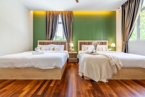 two beds in a bedroom with green walls and wooden floors at La Ferringhi Villa - Tropical Collection, by ALV in Batu Ferringhi