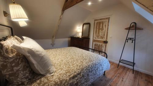 a bedroom with a bed with a dresser and a mirror at L'Astu'Cieux appartement triplex in Huelgoat