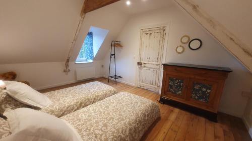 a attic room with two beds and a window at L'Astu'Cieux appartement triplex in Huelgoat
