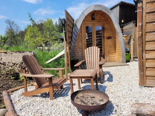 a group of chairs sitting in front of a cabin at Romantischer POD - Gegen Aufpreis mit Hot Tub - Whirlpool & Sauna in Hohenberg an der Eger