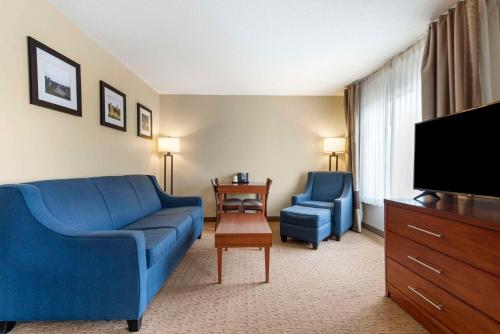 a living room with a blue couch and a tv at Comfort Inn & Suites Black River Falls I-94 in Black River Falls