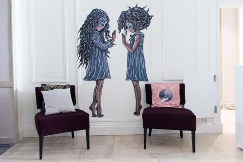 two girls mural in a room with two chairs at Hôtel François 1er in La Rochelle