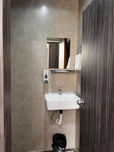 a bathroom with a sink and a mirror at Hotel soumya sarovar in Jagdalpur