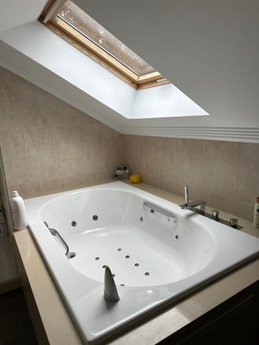 a large white tub in a bathroom with a skylight at Disfrutar de las rias baixas in Vilagarcia de Arousa