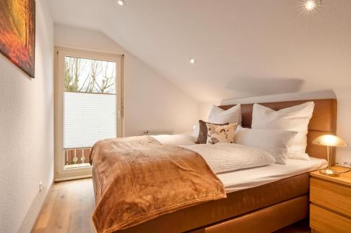 a bedroom with a bed with white sheets and a window at Haus Christof in Bodenmais