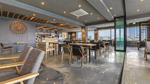 ein Restaurant mit Tischen und Stühlen und eine Bar in der Unterkunft Gangneung Haerang Pension in Gangneung