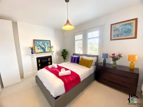 - une chambre avec un grand lit et une cheminée dans l'établissement Cambridge Stays 3BR house, easy walk to city center, 2 showers, garden, 2 free parking spaces, à Cambridge