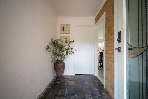 a hallway with a plant in a vase next to a door at Devon Meadows Farm Escape in Devon Meadows