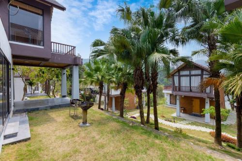 a view of the yard of a house with palm trees at Thang Mây Village - Ba Vì in Ba Vì