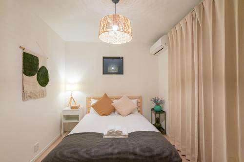 a bedroom with a bed and a pendant light at 静和 旅タイム粉滨 in Osaka