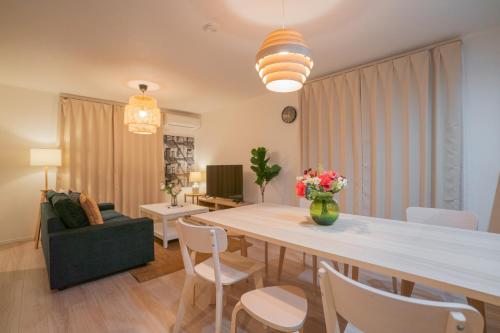 a dining room and living room with a table and chairs at 静和 旅タイム粉滨 in Osaka
