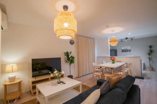 a living room with a couch and a dining room at 静和 旅タイム粉滨 in Osaka