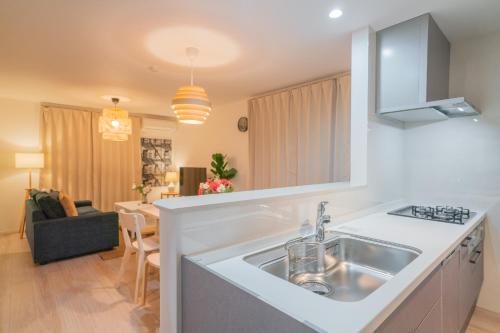 a kitchen with a sink and a living room at 静和 旅タイム粉滨 in Osaka
