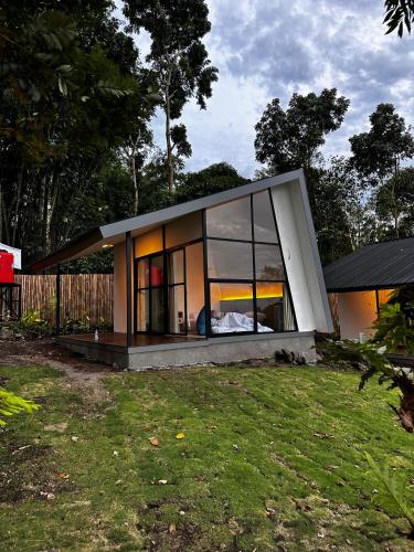 a small house with a large window on a yard at villa heve glamping in Kaliurang