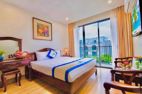 ein Schlafzimmer mit Bett, Schreibtisch und Fenster in der Unterkunft Coral Hotel Phu Quoc in Phu Quoc