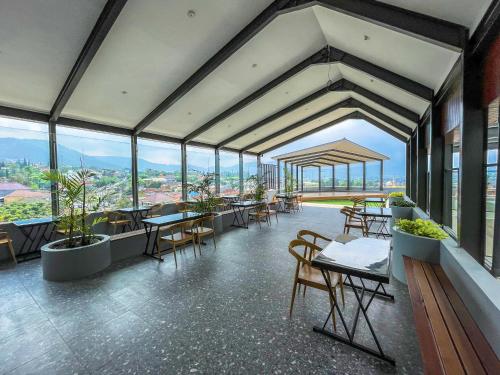 a large room with tables and chairs and windows at Samara Resort in Batu