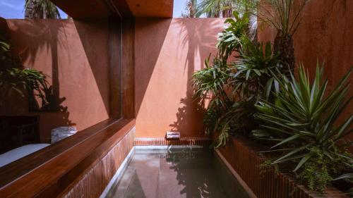a swimming pool with plants in a building at Further Hotel in Canggu