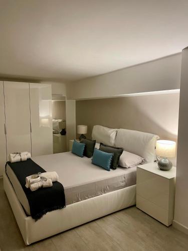 a bedroom with a large white bed with blue pillows at URBAN HOME in Bari