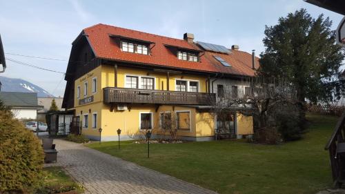 a yellow house with a red roof at Apartments Vidmar near Bled in Lesce