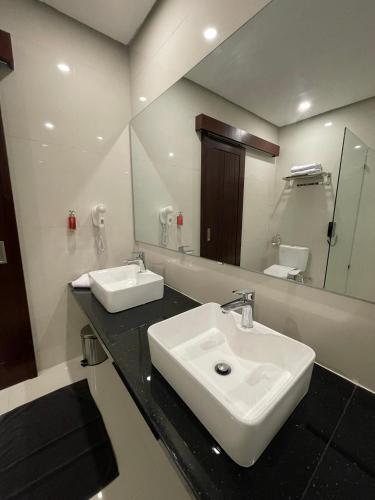 a bathroom with two sinks and a large mirror at Samara Resort in Batu