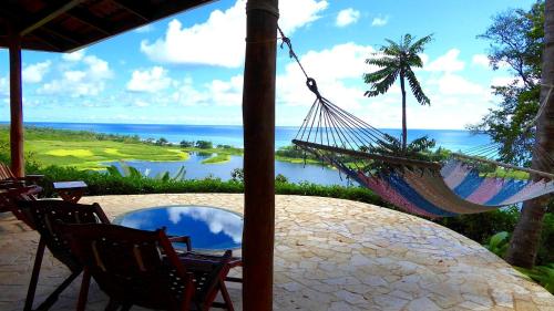 a hammock on a patio with a view of the ocean at LagunaVista Villas in Carate