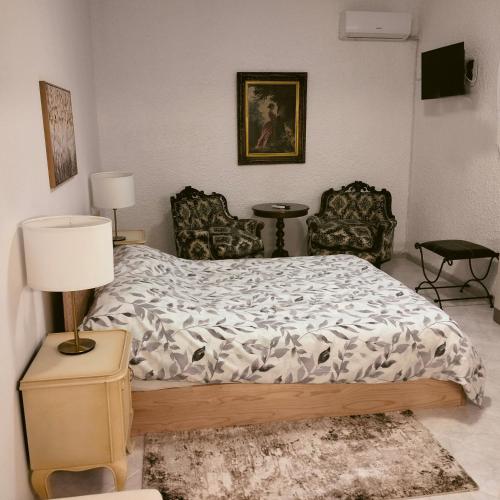 a bedroom with a bed with two chairs and a lamp at PALIOKTIMA - SLEEP n GO in Néon Rýsion