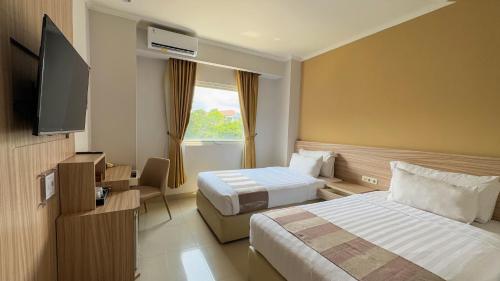 Postel nebo postele na pokoji v ubytování Lorin Syariah Solo Hotel