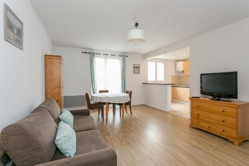 un salon avec un canapé et une télévision dans l'établissement Résidence Hôtel Les Joséphines, à Rueil-Malmaison