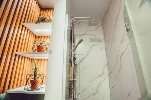 a bathroom with a shower with a glass door at La Joya Suite in Naga