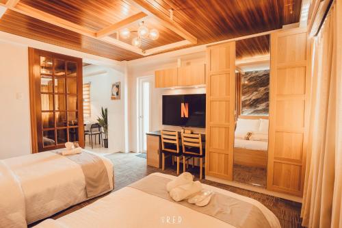 a hotel room with two beds and a television at La Joya Suite in Naga
