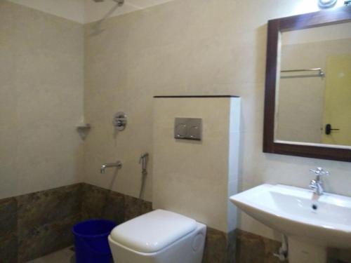 a bathroom with a sink and a toilet and a mirror at Highrange Plaza in Thekkady